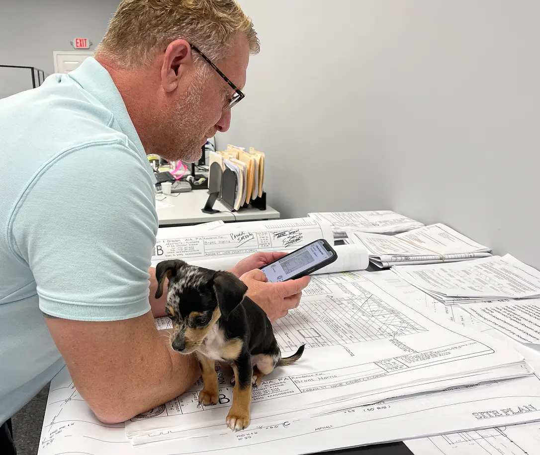 John overlooking house plans with his dog